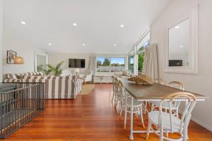 a dining room and living room with a table and chairs at First floor apartment in Taupo +5 photos