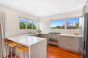 a kitchen with white cabinets and a white counter top at First floor apartment in Taupo