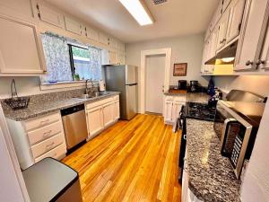 a kitchen with white cabinets and a wooden floor at The Virginia Blue- Walk To Downtown Prescott in Prescott +5 photos