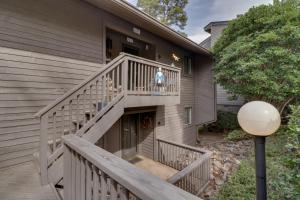 a woman standing on the stairs of a house at Hot Springs Condo with Lake Access and Community Pool in Hot Springs