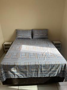 a bed with two pillows on it in a bedroom at Apartamento Central em Alfenas in Alfenas