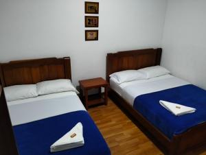 two beds sitting next to each other in a room at Hotel café Arábico in Líbano