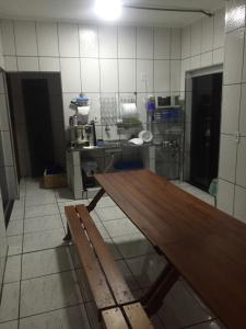 a kitchen with a wooden table in a room at Pousada Tilu in Aparecida