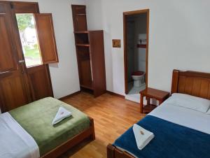 a room with two beds and a toilet in it at Hotel café Arábico in Líbano
