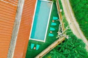 einen Blick über einen Pool mit grünem Gras in der Unterkunft Starloka Saba Bali Hotel in Blahbatu