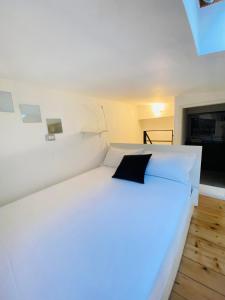 ein Schlafzimmer mit einem weißen Bett und einem schwarzen Kissen in der Unterkunft Isola View Bosco Verticale in Mailand
