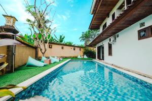 ein Swimmingpool im Hinterhof einer Villa in der Unterkunft Starloka Saba Bali Hotel in Blahbatu