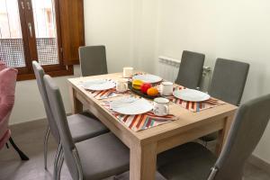 a wooden table with plates and fruit on it at El Refugio de Doña Jimena in Burgos