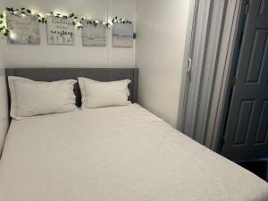 a bed with white sheets and pillows in a bedroom at Tiny wooden home in Vega Baja +18 photos