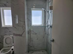 a bathroom with a glass shower with a toilet at Pyramid beach house in Karikari Peninsula +13 photos