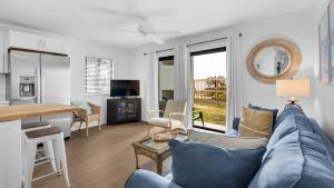 Beachside Condo 13 في شاطئ سانتا روزا: غرفة معيشة مع أريكة زرقاء وطاولة