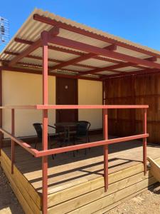 a pergola on a deck with a table at Bright Cabin Park in Bright