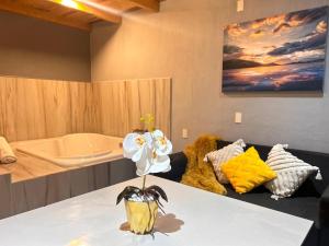 a room with a couch and a vase with flowers on a table at Departamento en Mazamitla in Mazamitla +3 photos