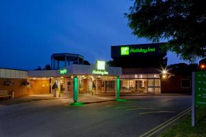 Un edificio con un estacionamiento enfrente. en Holiday Inn Norwich, Ipswich Road by IHG, en Norwich