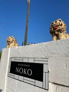 宮古島にあるprivate house nokoの二重の像がある民家の看板