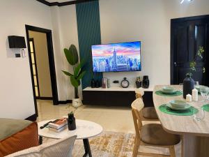 un salon avec une table et une télévision dans l'établissement Wink City 4th Patong, à Patong Beach