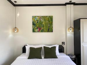 - une chambre avec un lit et des oreillers verts dans l'établissement Wink City 4th Patong, à Patong Beach 7 autres photos