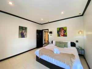 - une chambre avec un grand lit et des photos sur le mur dans l'établissement Wink City 4th Patong, à Patong Beach