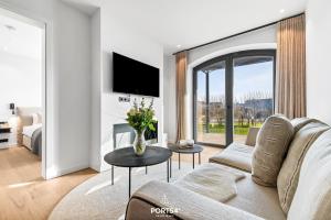Una sala de estar con un sofá y una ventana grande. en Manhattan Suite List auf Sylt, en List