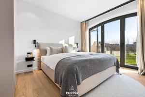 Un dormitorio con una cama y una ventana grande. en Manhattan Suite List auf Sylt, en List