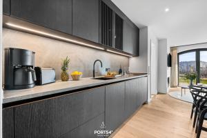 Una cocina con gabinetes negros y encimera. en Manhattan Suite List auf Sylt, en List 26 fotos más