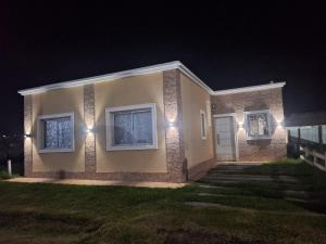 a house with lights on the side of it at night at Casa 3 dormitorios en Barrio Privado con vigilancia en Haras el Terraplen, General Rodriguez, con Pileta, quincho, parrilla in General Rodríguez