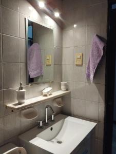 a bathroom with a sink and a mirror and purple towels at Depto cómodo por Av Libertador in San Juan