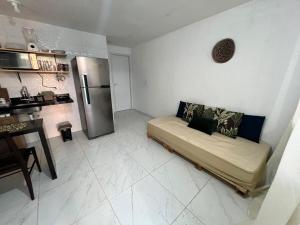 ein Wohnzimmer mit Couch und Kühlschrank in der Unterkunft Vila Negreiros Serra Negra Casa 1 in Bezerros