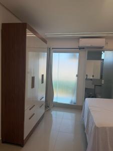 a bedroom with a bed and a dresser and a window at Apto com piscinas e pé na areia in Valença