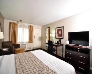 サンダスキーにあるBaymont by Wyndham Sanduskyのベッド1台、薄型テレビが備わるホテルルームです。