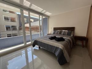 Un dormitorio con una cama y una ventana grande. en A pasos del metro Steps away from the subway, en Santiago 27 fotos más