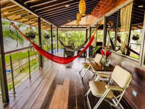 a hammock in the middle of a room with windows at Casa Hotel La Cherna in Bahía Solano