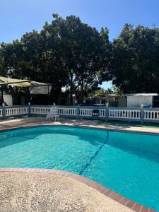 a swimming pool with a white fence around it at Tiny wooden home in Vega Baja