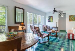 a living room with a table and chairs at Plantation House Trinidad suite in Playa del Carmen