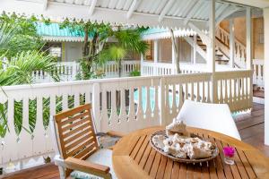 a wooden table and chair on a porch with a table and a bowl of food at Plantation House Trinidad suite in Playa del Carmen