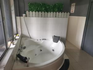 a white tub in a bathroom with a window at Private Sauna, Gym, Studio and SofaBed in Miri