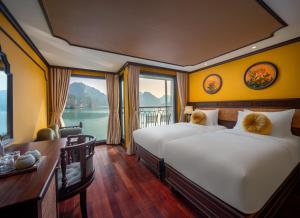 two beds in a room with a view of the water at Indochine Grand Lan Ha Bay in Ha Long