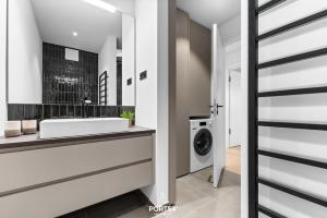 a bathroom with a sink and a washing machine at Brooklyn Bridge Suite List auf Sylt in List