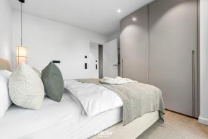 a white bedroom with a large white bed with pillows at Brooklyn Bridge Suite List auf Sylt in List