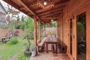 a wooden pavilion with a wooden table in a garden at Khai Quynh Villa 3 - Venuestay in Khu Chi Lăng