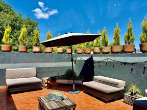 底拉斯卡拉Hotel Boutique Casa Catalá的庭院配有遮阳伞、椅子和桌子。