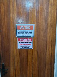 a sign on a wooden door with a sign on it at Apto no Centro de São Leopoldo in São Leopoldo