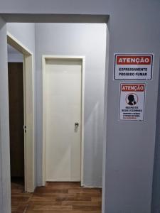 a white door with a fire sign on a wall at Apto no Centro de São Leopoldo in São Leopoldo