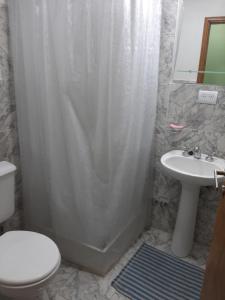 a bathroom with a shower with a toilet and a sink at Los girasoles in Tandil