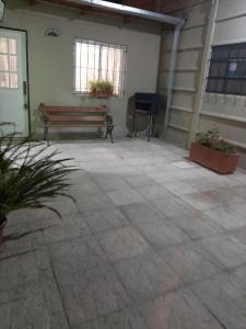 a patio with a bench and a chair in a building at Los girasoles in Tandil