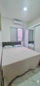 Un dormitorio con una cama grande y dos ventanas. en Apartamento completo Fit Coqueiro 1 Cop 30, en Ananindeua