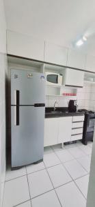 cocina blanca con nevera y fregadero en Apartamento completo Fit Coqueiro 1 Cop 30, en Ananindeua