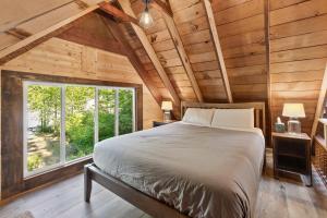 a bedroom with a bed and a large window at PNW River Cabin in Darrington