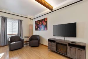 a living room with a flat screen tv on the wall at Snowcreek Suite - Dogwood - Hot tub - Kitchenette in Leavenworth