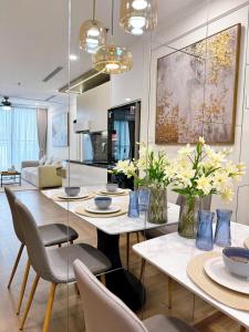 a living room with a dining table and chairs at Luxury Apartment in Vinhomes Times City - KaBi Home in Hanoi